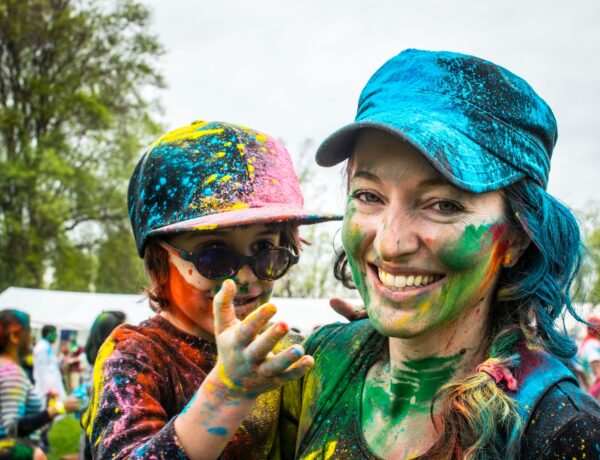 woman carrying child on color run