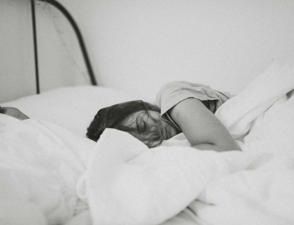 grayscale photo of sleeping woman lying on bed