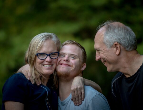 photo of two man and one woman standing near tree